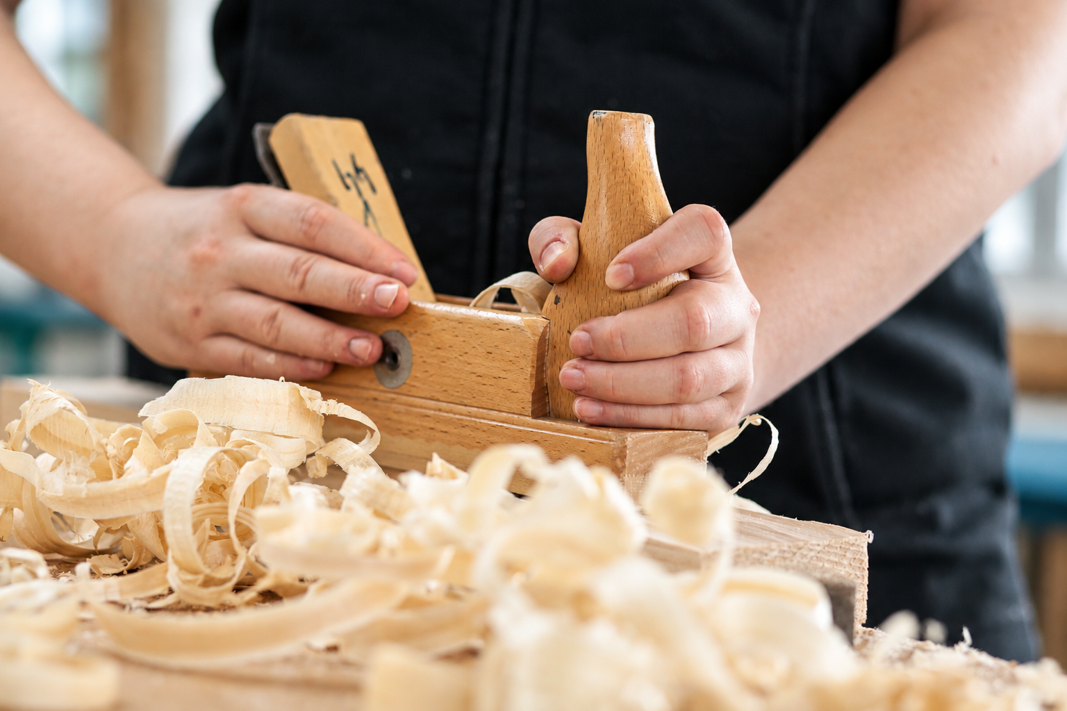Hände bearbeiten ein Werkstück aus Holz
